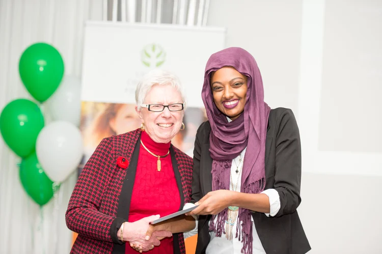 Two women holding an award